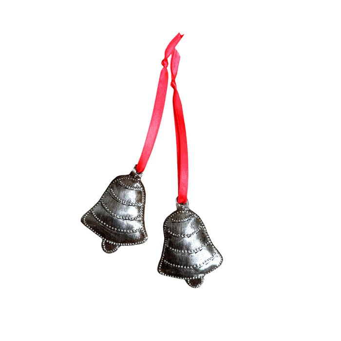 Brushed metal bell ornaments with red ribbon on white background.