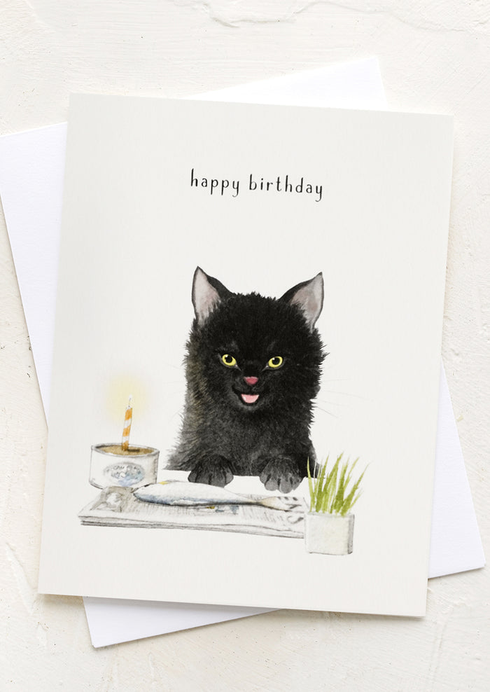 A card with illustration of cat eating a fish, text reads "happy birthday".