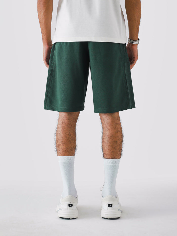 Deep Green Aim Shorts on model, relaxed-fit men's gym and casual shorts by GROOVY Pakistan