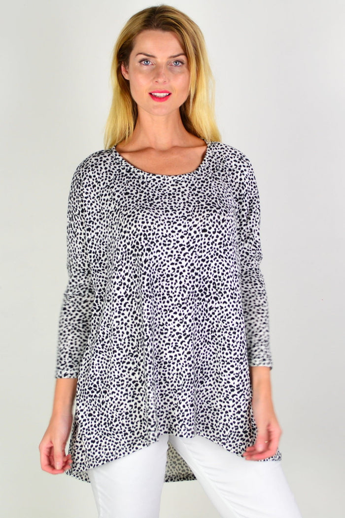Black and white spotted Caroline Morgan tunic top with a hi-low hem, styled with long sleeves and a relaxed fit.