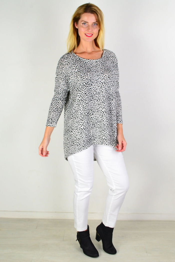 Black and white spot hi-low tunic top by Caroline Morgan with flowing fabric and stylish design, shown on a hanger.