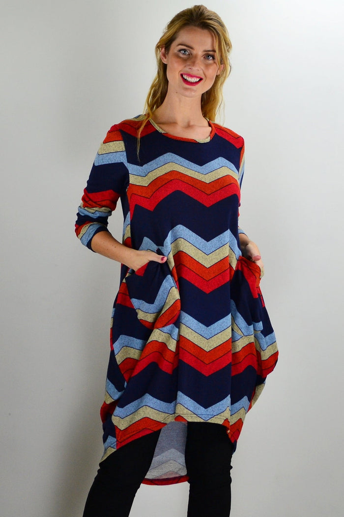 Hourglass Candy Lane wool knit tunic top hanging on a display, featuring a cozy, textured knit fabric and a relaxed fit.