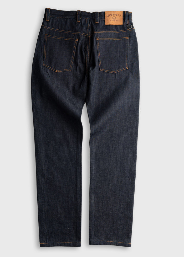 Dark denim jeans with visible orange stitching and a leather patch on the back waistband, displayed on a plain background.