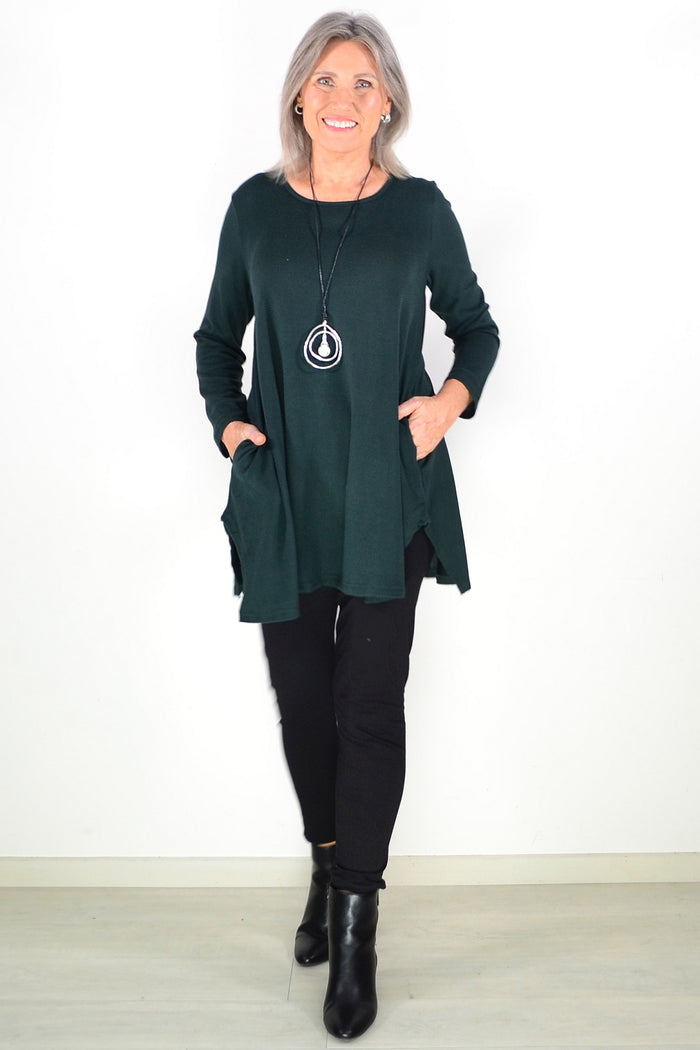 Dark green winter fleece tunic top by Hourglass Avalon, shown on a hanger with cozy, soft fabric and a relaxed fit.