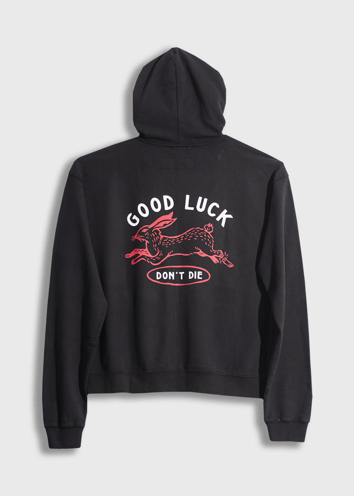 Black hoodie with "Good Luck Don't Die" and red rabbit design on back, conveying a bold, playful message.