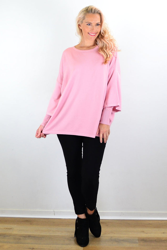 Cali&Co lush pink Debs double sleeve tunic jumper hanging on a rack, showcasing its soft fabric and stylish double sleeve design.