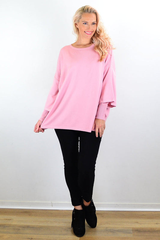 Cali&Co lush pink Debs double sleeve tunic jumper hanging on a rack, showcasing its soft fabric and stylish double sleeve design.