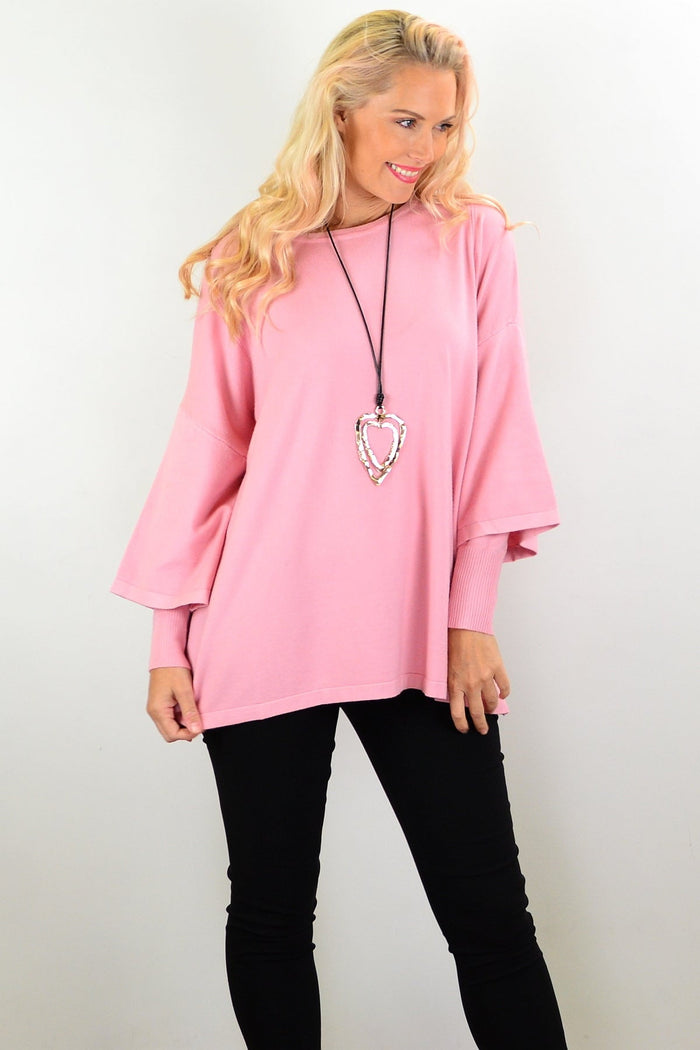 Lush pink Cali&Co Debs double sleeve tunic jumper displayed on a hanger, showcasing its soft fabric and stylish design.