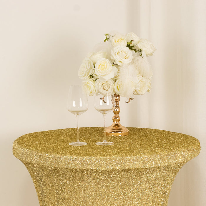 Gold glitter table with white rose bouquet and two wine glasses.