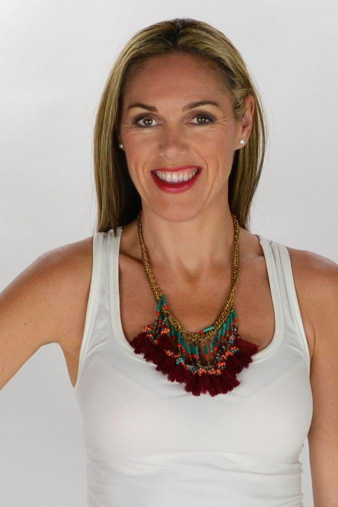 Red Tassels Necklace by I Love Tunics featuring vibrant tassels and a stylish design on a model.