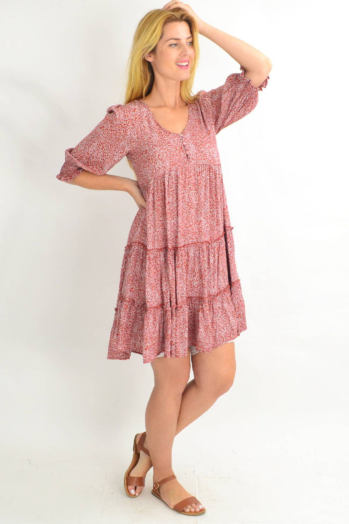 Rust smocking sleeve tiered tunic dress by Silver Wishes, featuring long sleeves and a flowing tiered design.