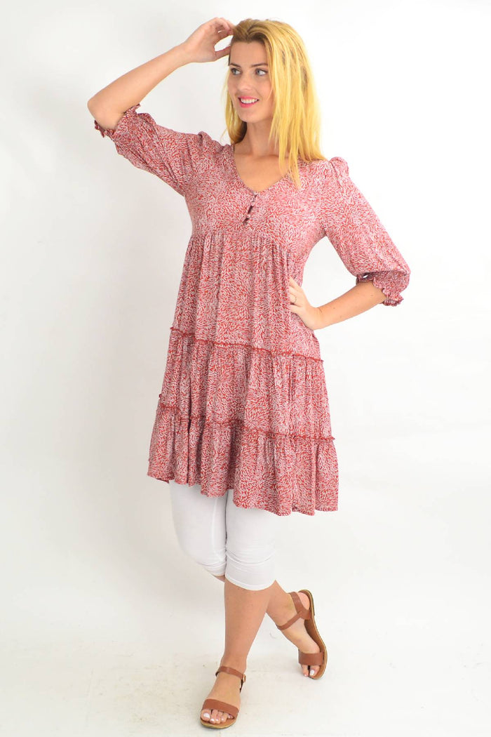 Rust-colored smocking sleeve tiered tunic dress by Silver Wishes, featuring flowing fabric and detailed sleeve design.