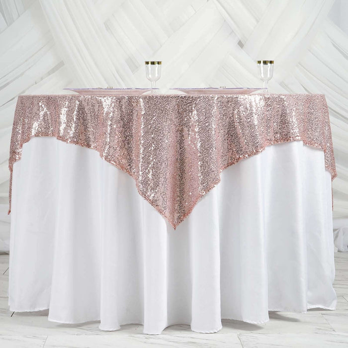 Rose gold sequin tablecloth draped over a white table.