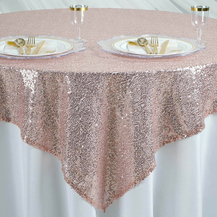 Rose gold sequin tablecloth draped elegantly over a table with dinnerware. #whtbkgd