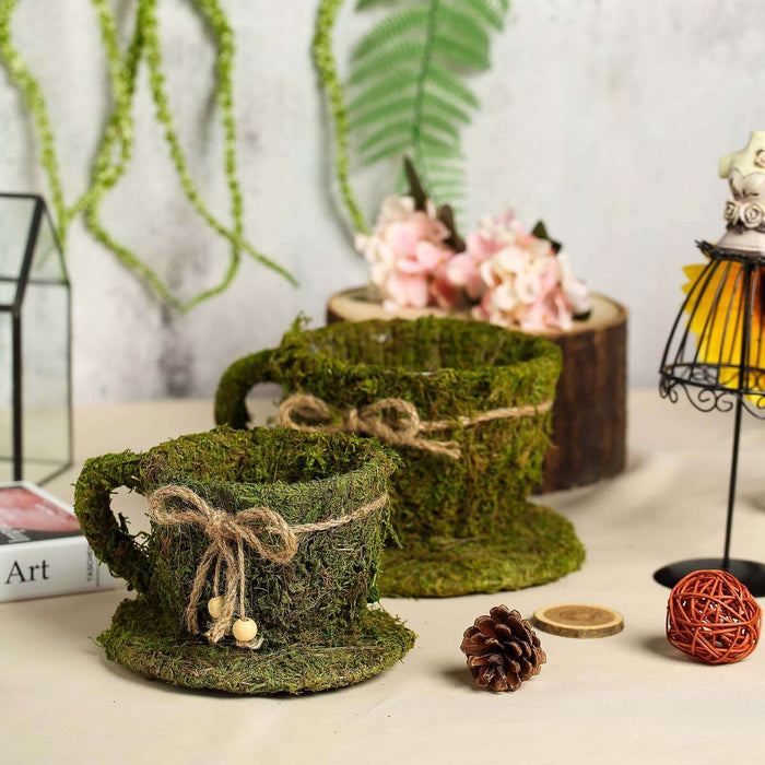 Moss-covered decorative cups with twine accents and natural elements.