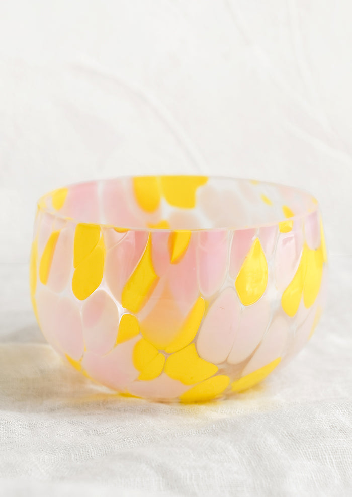 A speckled glass candy bowl in pink and yellow.