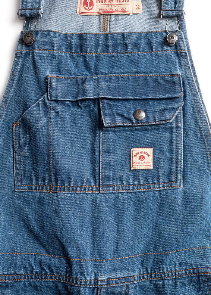 Denim overalls with a front pocket, button detail, and Iron & Resin label, showcasing rugged, high-quality craftsmanship.