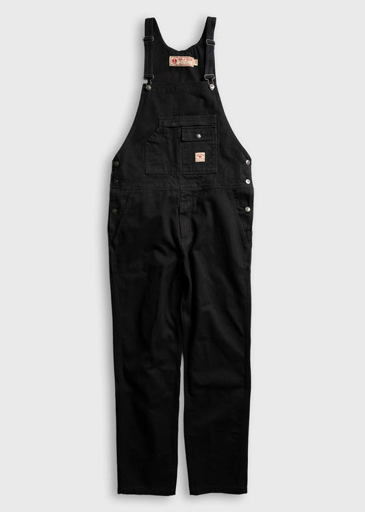 Black overalls with adjustable straps and front pocket, displayed on a white background, emphasizing classic workwear style.