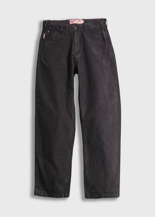 Black denim pants with a relaxed fit, featuring front pockets and belt loops, displayed on a white background.