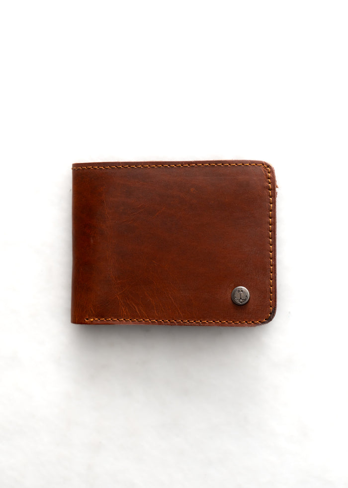 Brown leather wallet with visible stitching and a small metal logo on the corner, set against a plain white background.