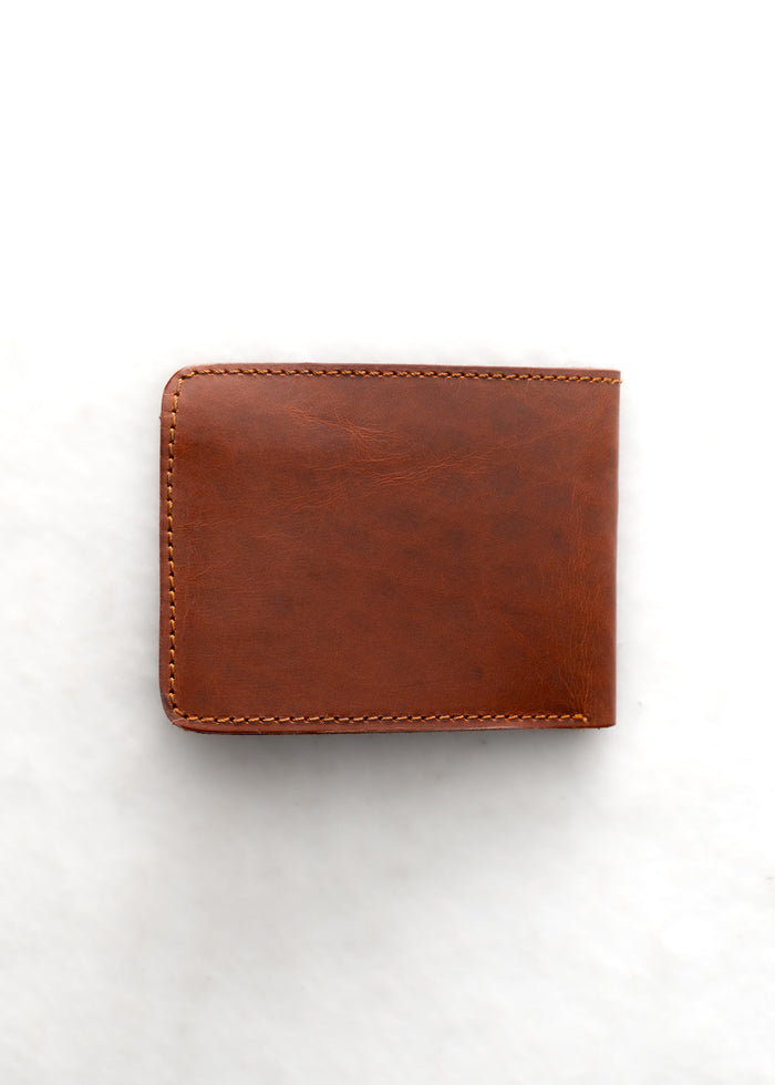 Brown leather wallet with visible stitching, placed on a white background, showcasing its simple and elegant design.