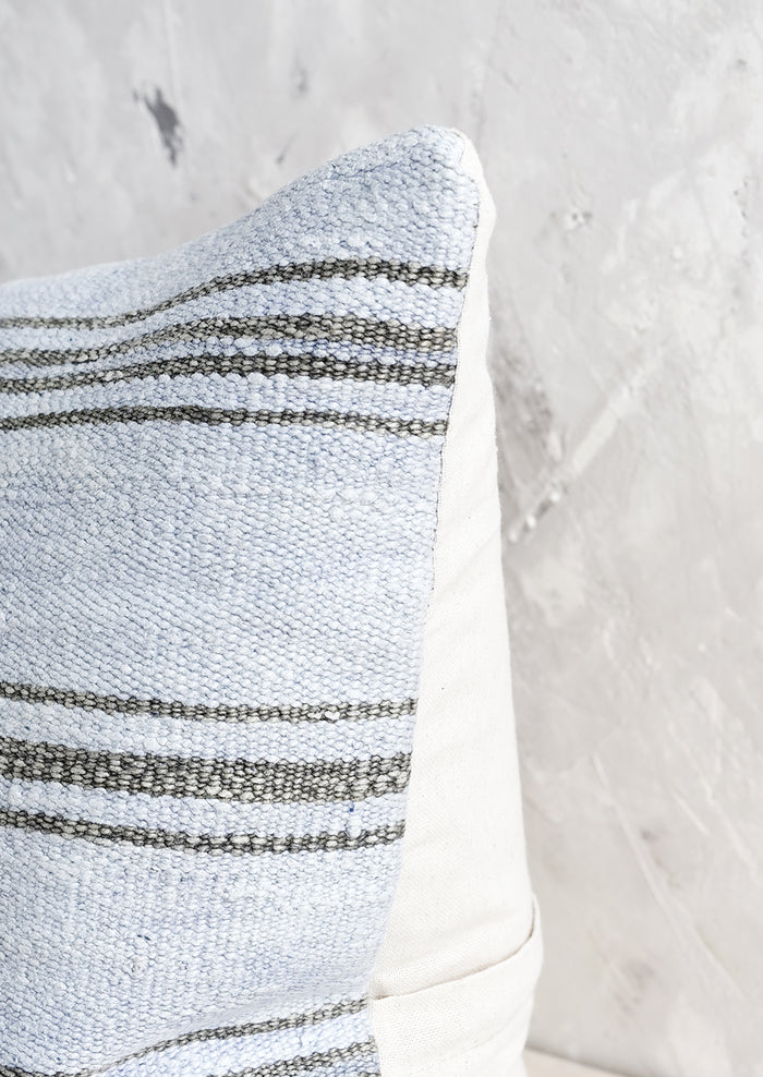 A square throw pillow in vintage light blue hemp with charcoal stripes.