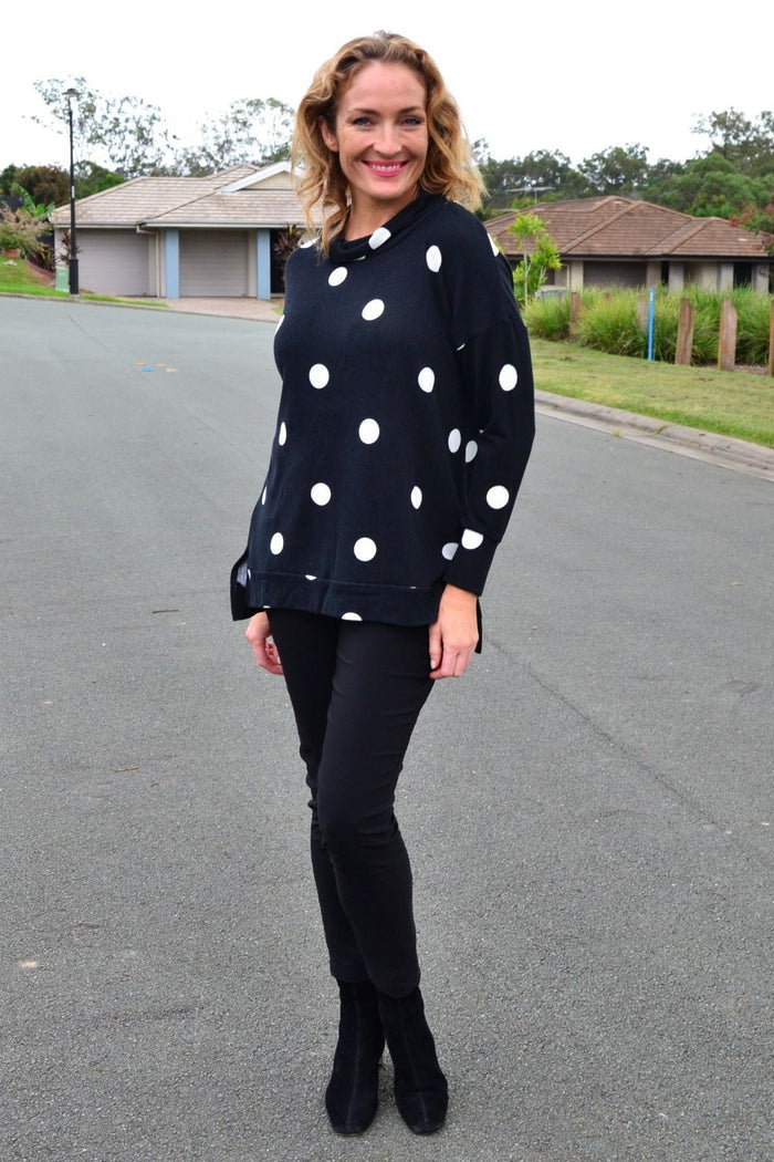 White Wishstone Spot Long Sleeve Fleece Tunic Top hanging on a hanger, showcasing its cozy fabric and relaxed fit.