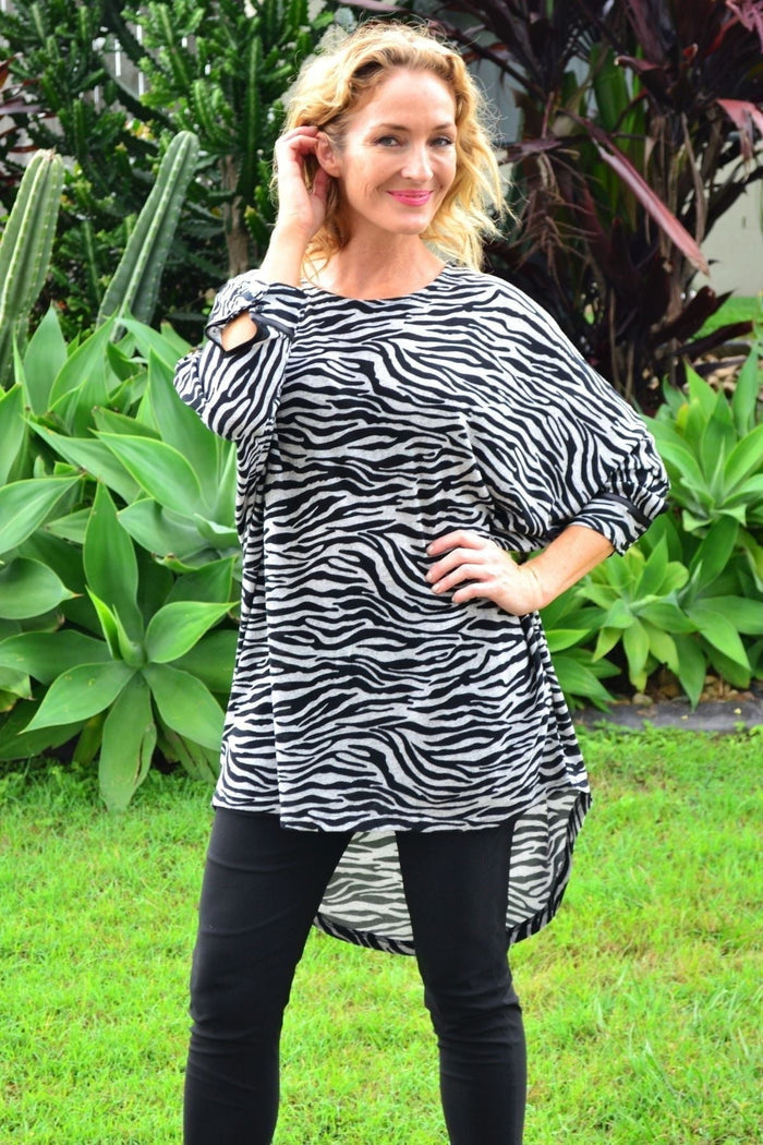 Zelma Zebra Relaxed Hi Low Hem Tunic Top by Caroline Morgan, featuring a zebra print and flowy hem, displayed on a hanger.